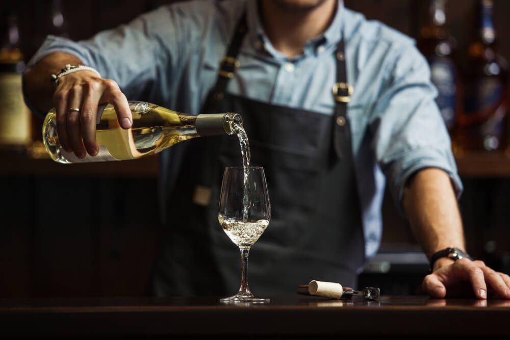 A bartender pouring a glass of wine at a Sonoma wine bar.
